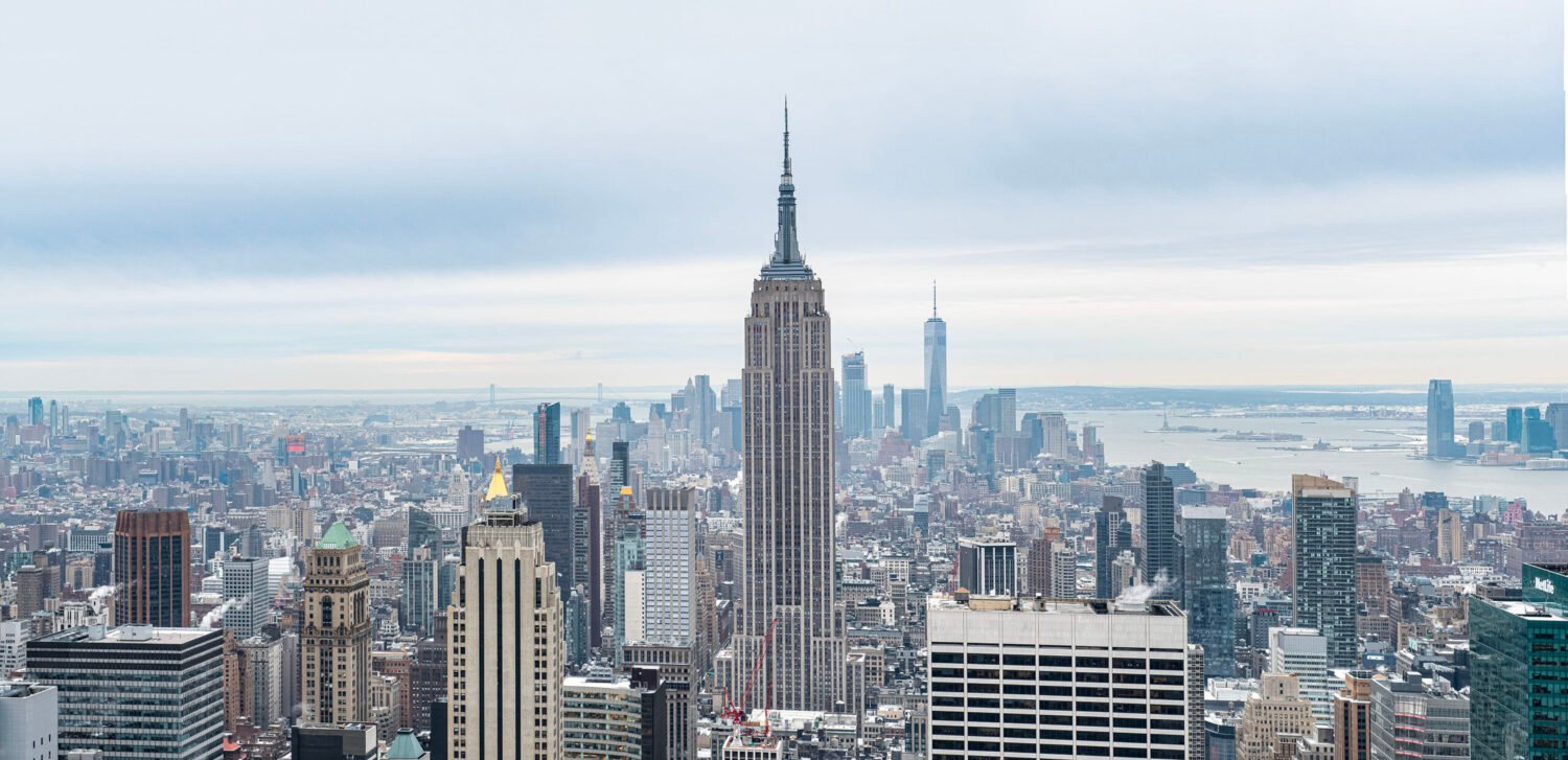 New York City skyline with the Empire State Building as a prominent feature on a cloudy day.